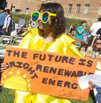 student holding renewable energy poster